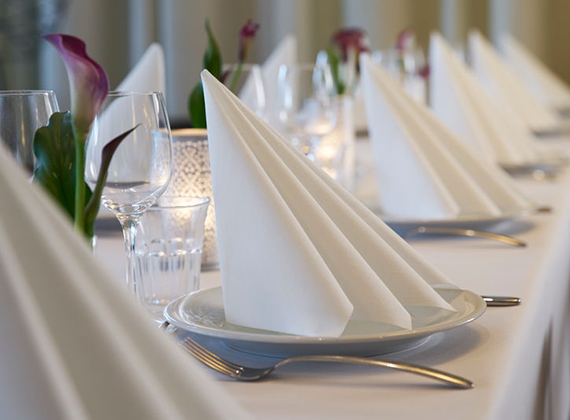 Folded white linen-feel Dunilin® napkins on a banquet table